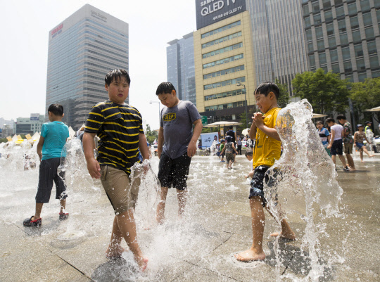 서울 최고기온 29도를 기록한 6일 오후 서울 광화문광장 분수대에서 어린이들이 물놀이를 하고 있다.